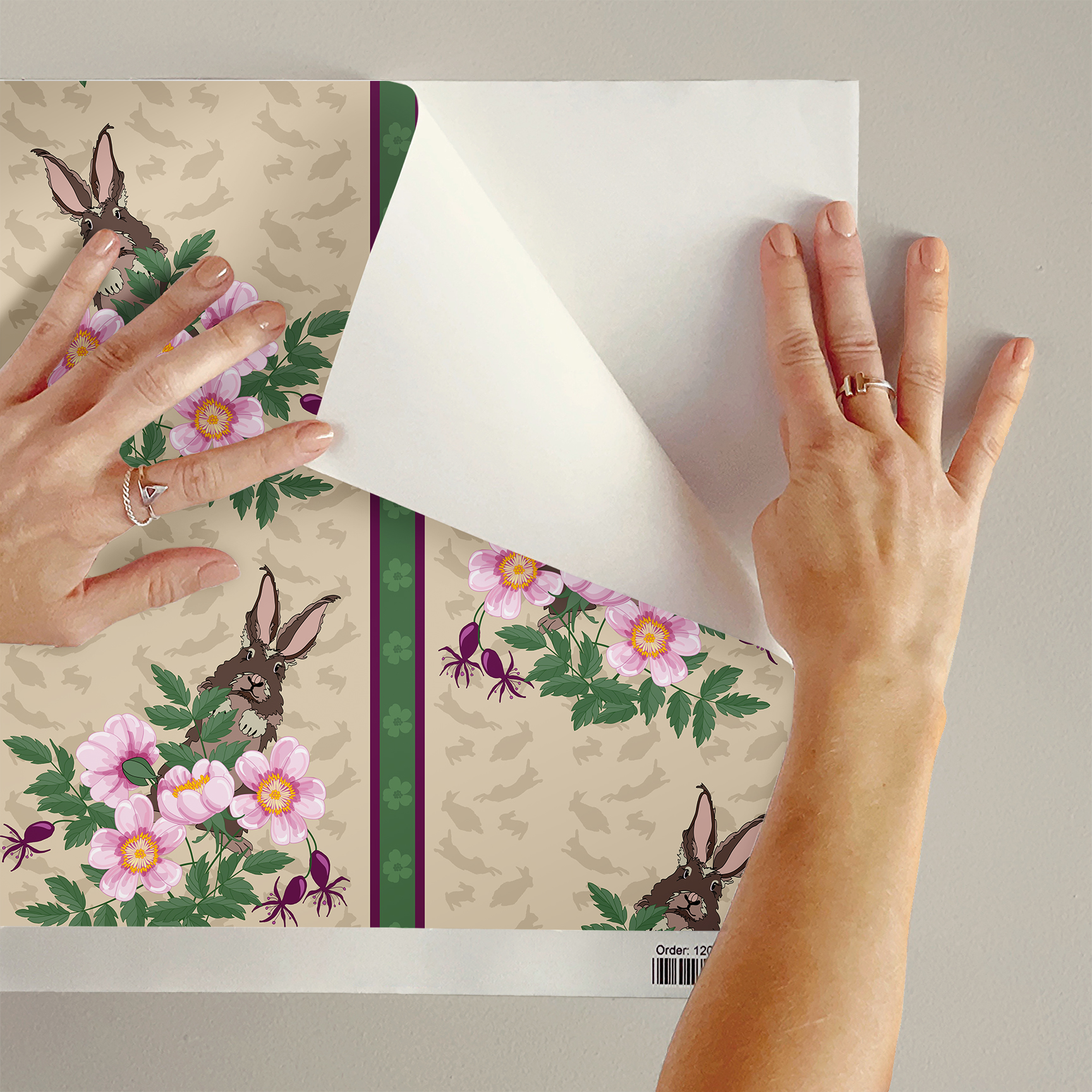 The artwork depicts a stylized brown hare partially concealed behind a cluster of green leaves and pink flowers with yellow centers. The background is dark green with subtle leafy patterns. Two vertical stripes—one dark purple and one green with small floral motifs—run along the left side, contrasting with the otherwise naturalistic elements. The composition balances the lively flora and fauna with a decorative, patterned design.